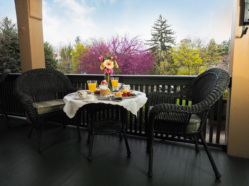 Breakfast served on the porch at the Bed & Breakfast in Asheville, with a cherry blossom tree in the background.