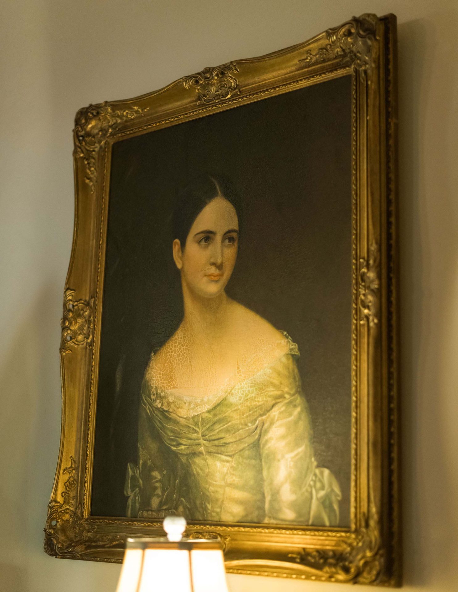 A close-up on a woman's portrait in a golden frame.