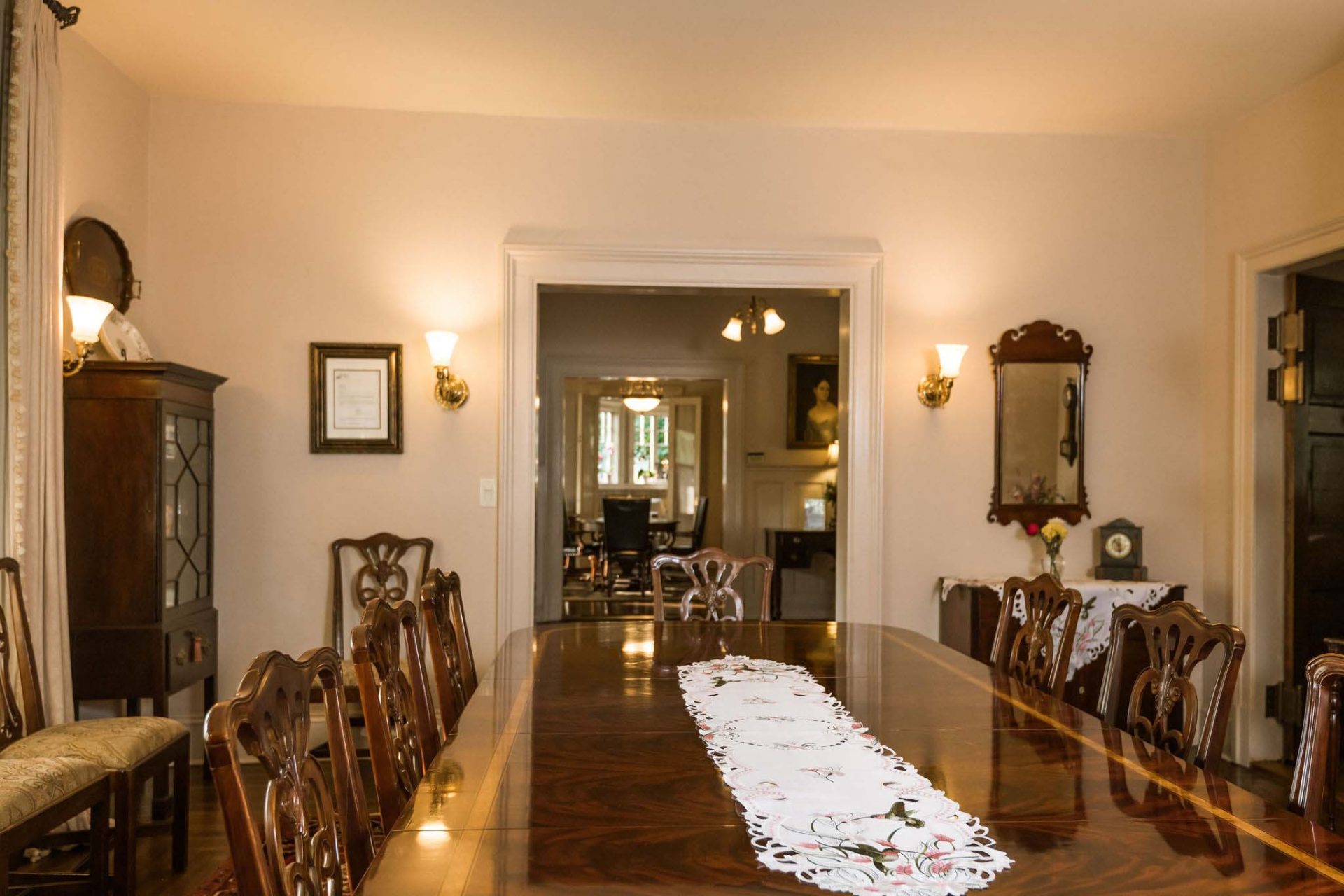A spacious dining room area with a big, dark wood dining table and wooden chairs, opening onto the Inn's foyer.