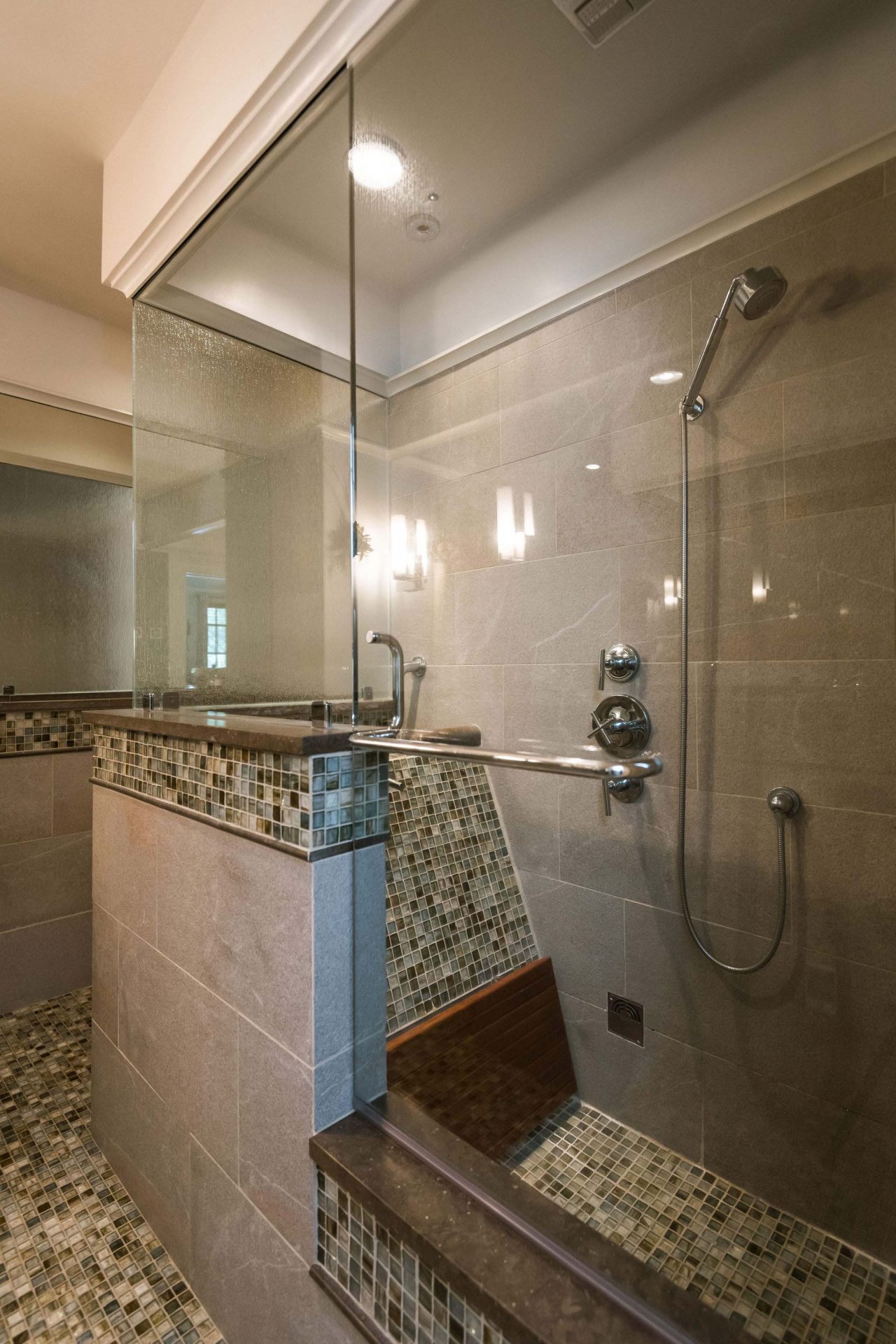 A luxurious bath with colorful fiber optic lighting, blue-lit glass sink, a roman bath and a rain head shower.