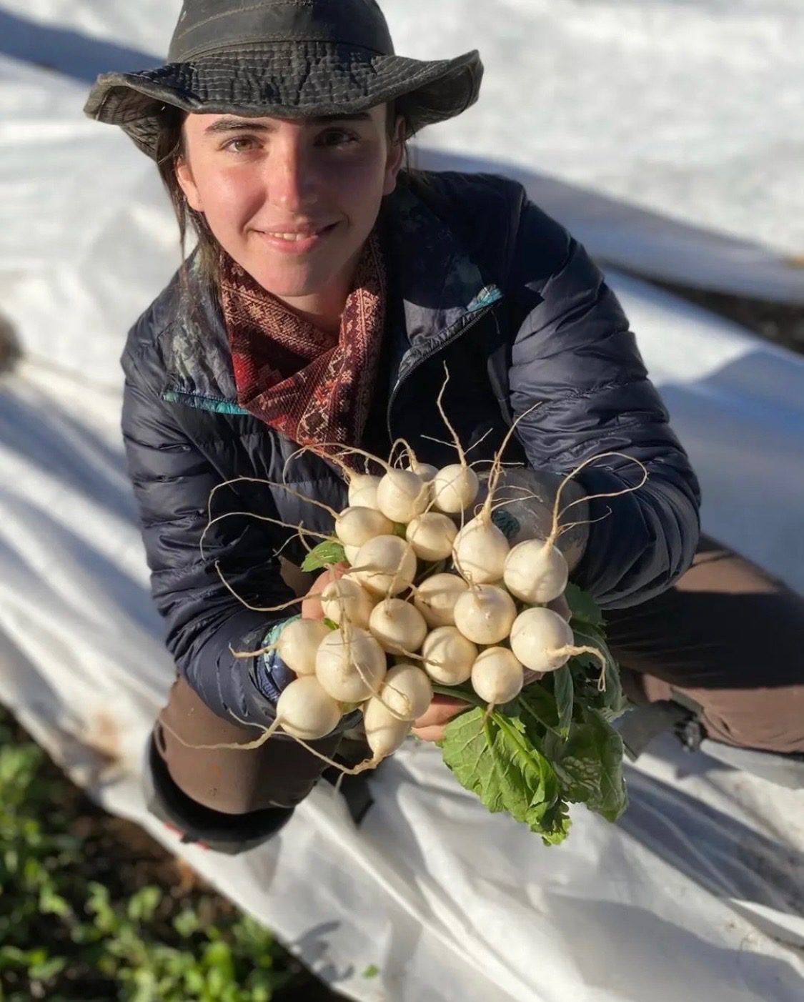 Savannah, owner of Encompass Farms in Asheville, holding local produce