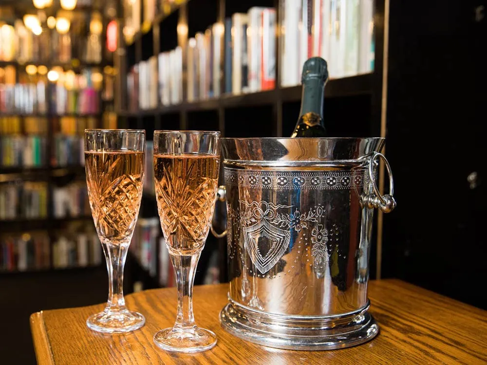 Two glasses of champagne at a table inside the Battery Park Book Exchange