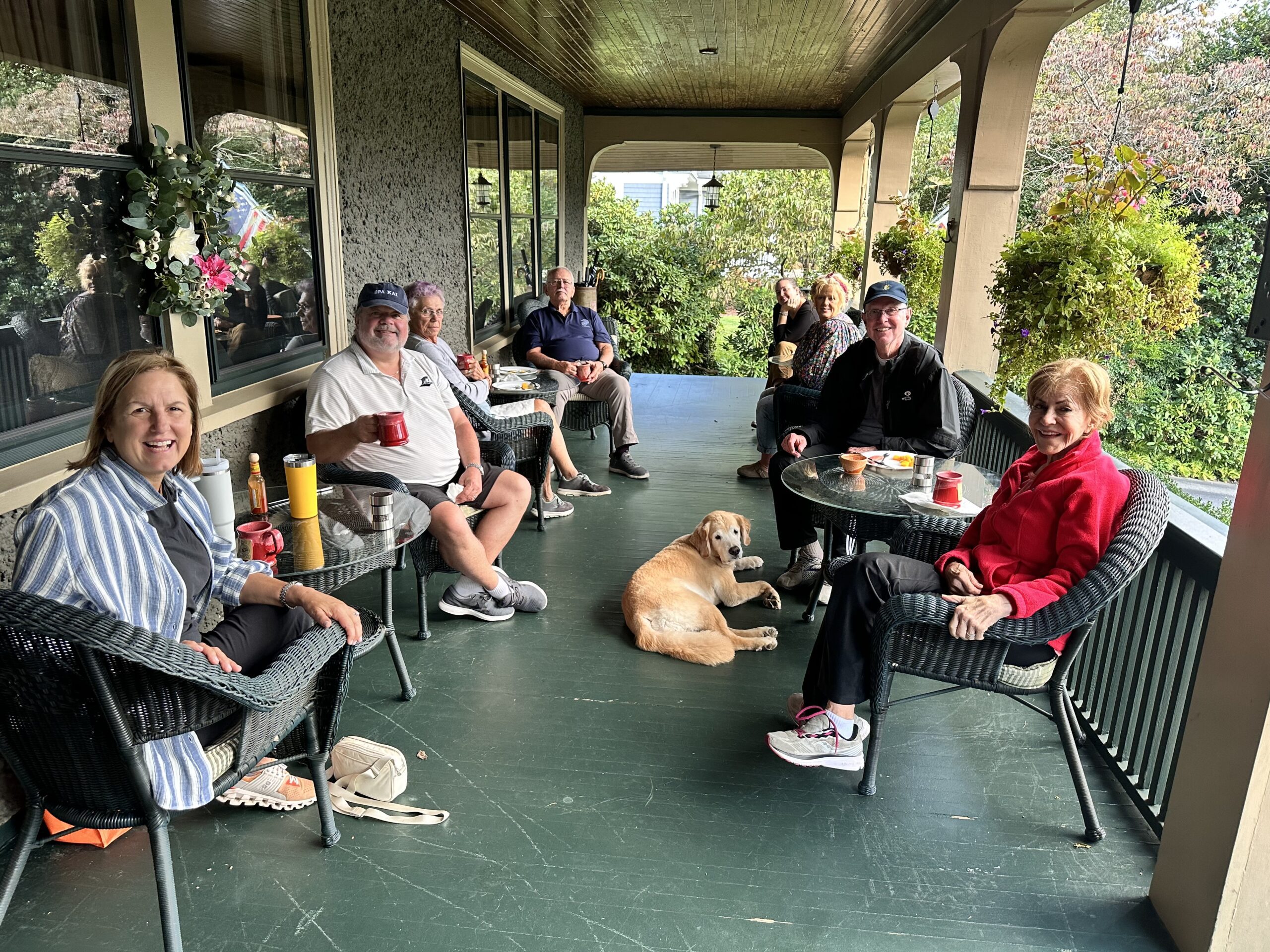 A group of guests sitting on the front porch of 1900 Inn on Montford